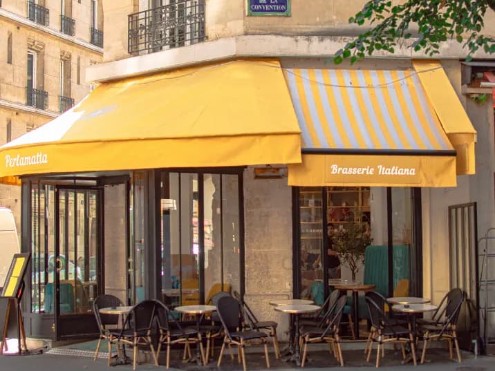 La facciata di Perlamatta all’angolo di rue de la Convention: tende gialle «Brasserie Italiana» e dehors
